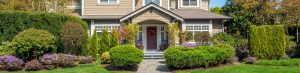Luxury house with nicely trimmed front yard lawn in a residential neighborhood. Home exterior.